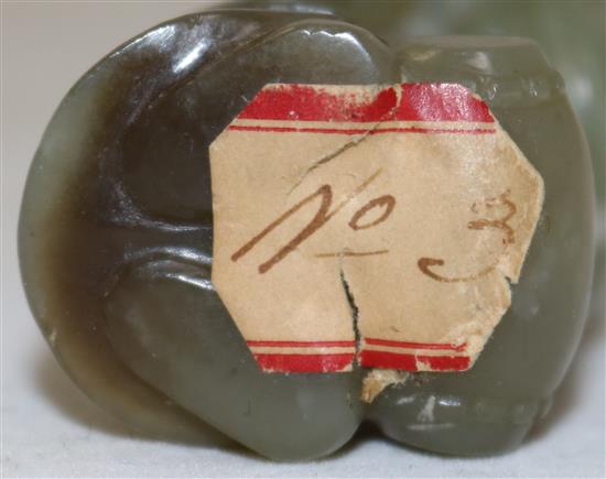 A Chinese celadon and brown jade group of Shou Lao and a boy standing upon a barrel, 18th/19th century, 7.3cm, ebonised wood stand